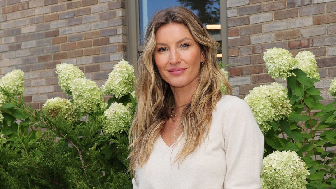 Gisele Bundchen standing in front of flowers