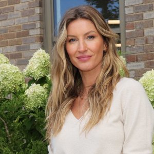 Gisele Bundchen standing in front of flowers