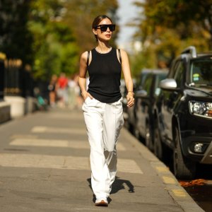 PARIS, FRANCE - AUGUST 30: Heart Evangelista wears sunglasses, a black tank top, white flare wide-leg jeans, Converse sneakers / shoes, during a street style fashion photo session, on August 30, 2022 in Paris, France. (Photo by Edward Berthelot/Getty Images)