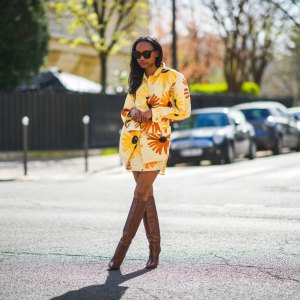 Emilie Joseph @in_fashionwetrust wears a yellow and orange floral print Jacquemus Murano dress with flap pockets and buttoned waist, Boots with Croc-effect leather knee-high boots from Paris Texas, on March 28, 2021 in Paris, France.