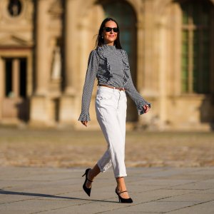 Alba Garavito Torre wears a gingham checkered black and white shirt with Long Sleeve Ruffles from Serendipia, Mom jeans in white from Maison 123 Paris, a brown leather thin belt, Black Mary Jane high heels shoes from Gucci, on October 10, 2021 in Paris, France.