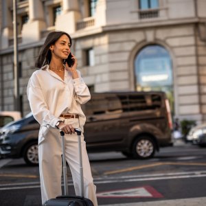 A happy pretty woman is walking on the street of Barcelona and enjoying a nice autumn day in the big city.