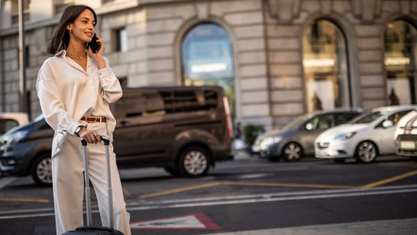 A happy pretty woman is walking on the street of Barcelona and enjoying a nice autumn day in the big city.