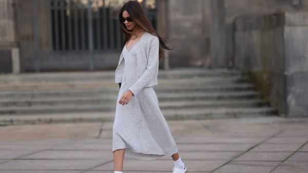 Jill Asemota seen wearing black vintage sunglasses, Dorothee Schumacher grey wool knit long dress, matching Dorothee Schumacher grey wool knit cardigan jacket, white cotton socks, Adidas white leather Samba sneakers, on November 04, 2023 in Berlin, Germany.