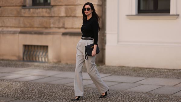 Leo Eberlin seen wearing Bottega Veneta black sunglasses, Leo Mathild jewelry / diamond bracelet and rings, Allude x Leo Mathild cashmere wool knit buttoned body, Toteme black leather belt, Velaa light grey elegant suit pants, Hermès black leather clutch bag and Saint Laurent black varnished leather heels / pumps, on February 25, 2024 in Berlin, Germany.