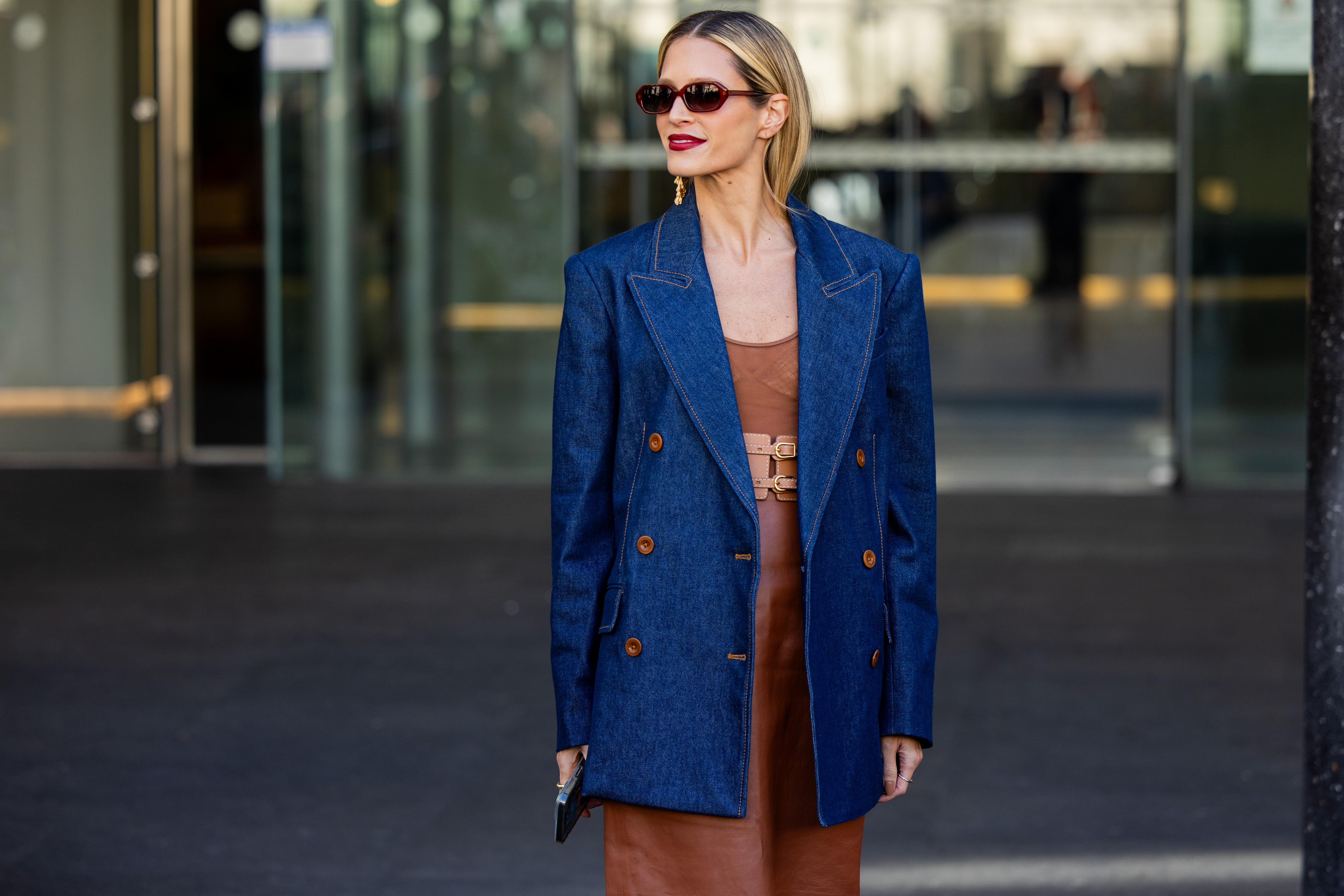 Helena Bordon wears denim blazer, brown dress, sunglasses, golden earrings outside Zimmermann during the Womenswear Fall/Winter 2024/2025 as part of Paris Fashion Week on March 04, 2024 in Paris, France.