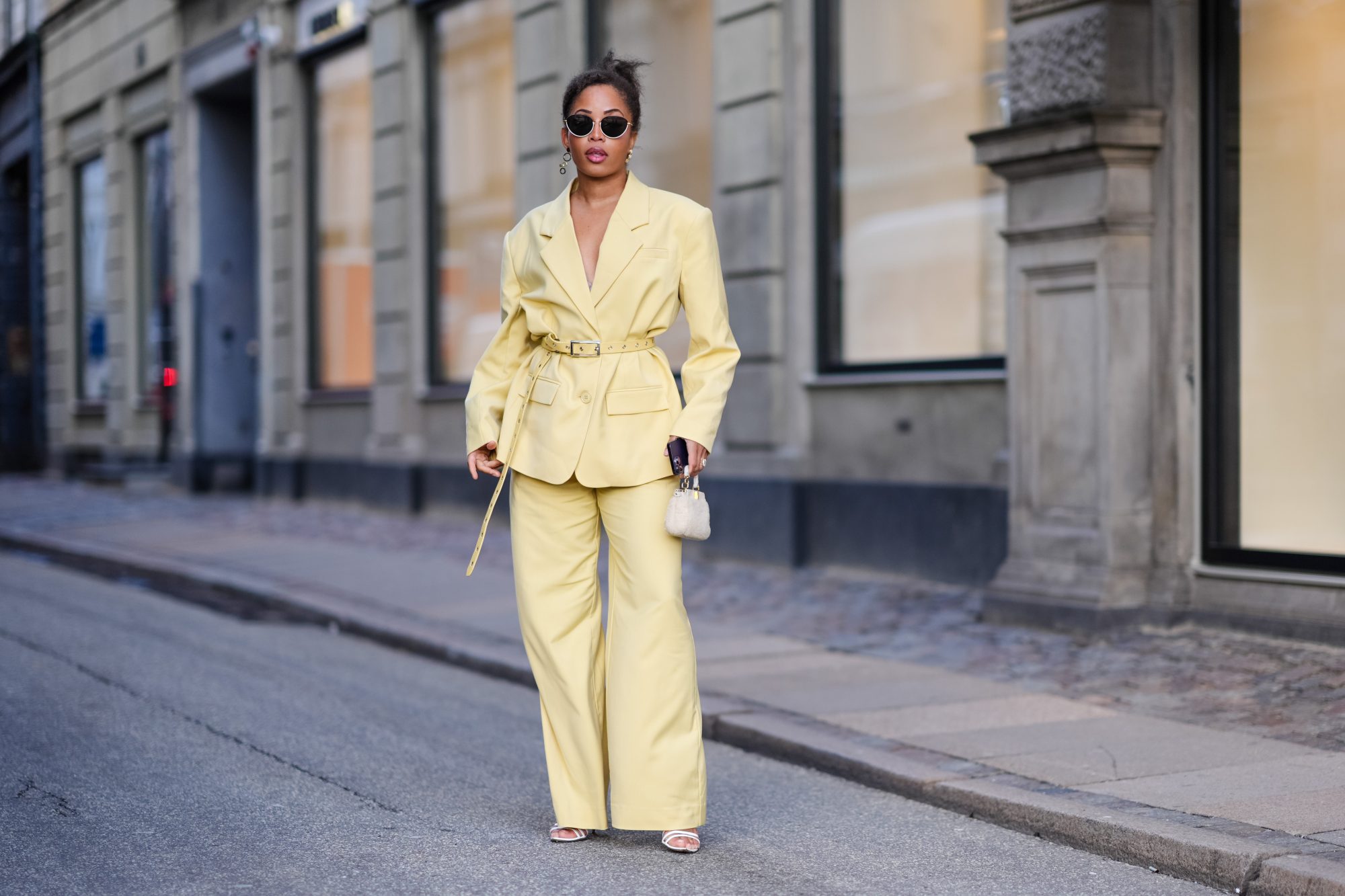 COPENHAGEN, DENMARK - FEBRUARY 01: Ellie Delphine wears sunglasses , a pastel pale yellow oversized blazer jacket , a belt, flared pants , outside Mark Kenly Domino Tan, during the Copenhagen Fashion Week AW24 on February 01, 2024 in Copenhagen, Denmark. (Photo by Edward Berthelot/Getty Images)