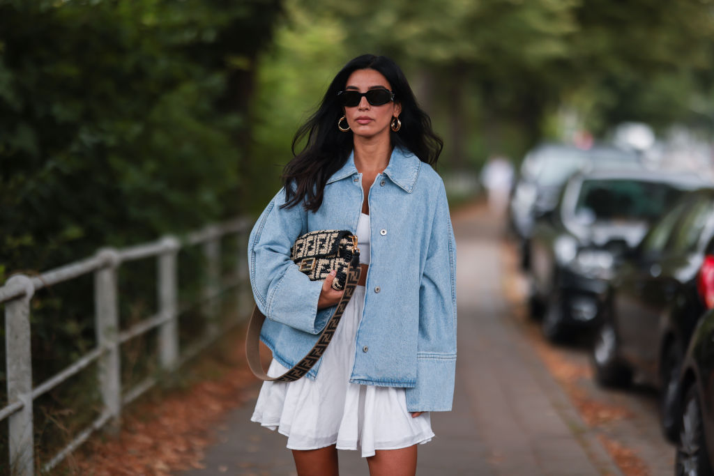 HAMBURG, GERMANY - JULY 27: Semra Hunt wearing Loewe jeans jacket, Fendi baguette and American Vintage white skirt and top on July 27, 2021 in Hamburg, Germany. (Photo by Jeremy Moeller/Getty Images)