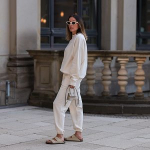 HAMBURG, GERMANY - AUGUST 16: Elise Seitz seen wearing white sunglasses from Celine, a creme white SohoStudios sweater, a creme white SohoStudios jogger pants, creme white linen Jacquemus Chiquito bag and beige suede Birkenstock Arizona sandals, on August 16, 2022 in Hamburg, Germany. (Photo by Jeremy Moeller/Getty Images)