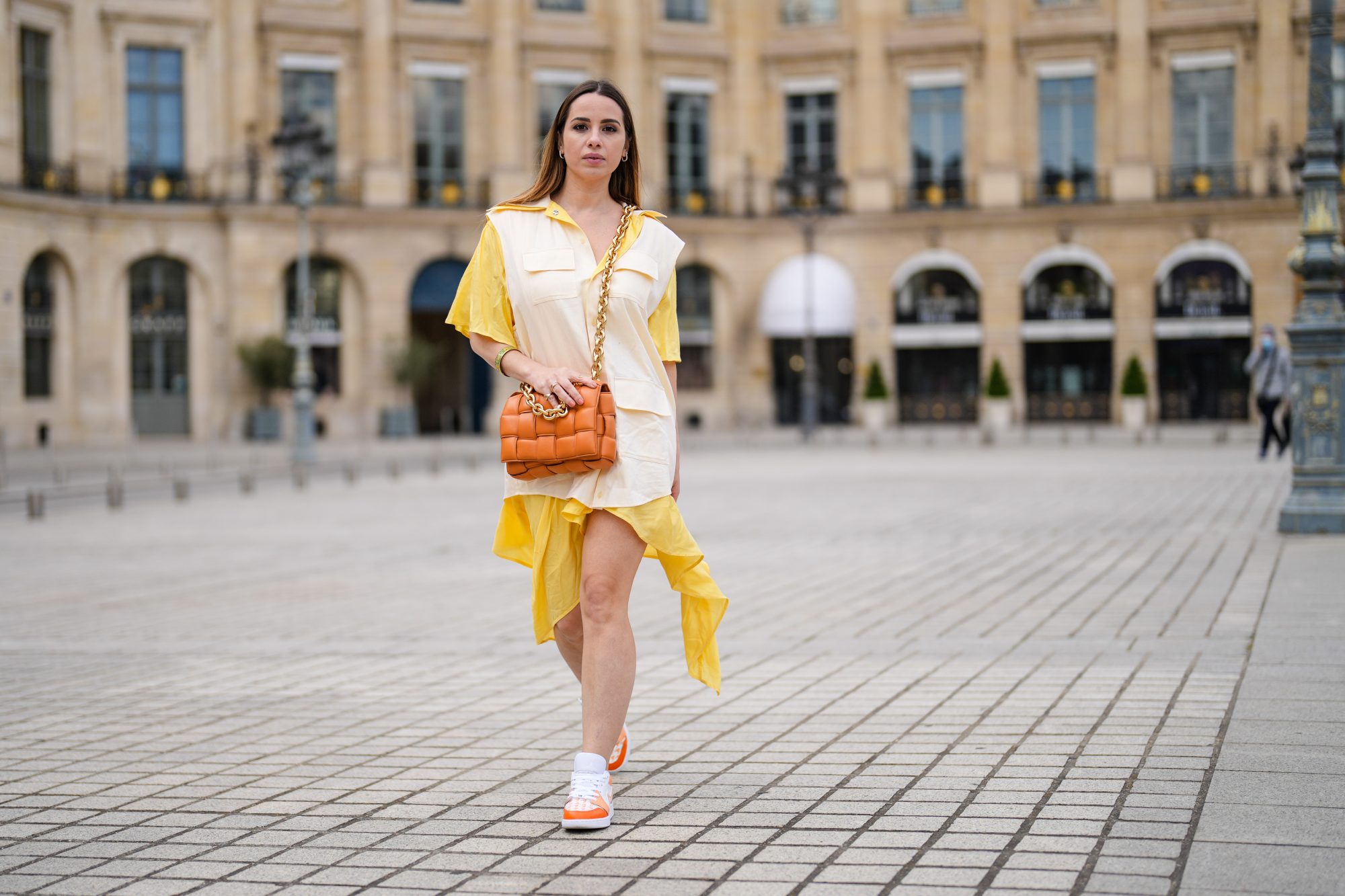PARIS, FRANCE - MAY 07: Maria Rosaria Rizzo @lacoquetteitalienne wears a pale pastel yellow and beige shirt / flowing dress from Victoria/Tomas, a brown leather Bottega Veneta bag, sneakers from Nike Air Jordan with orange printed houndstooth patterns, on May 07, 2021 in Paris, France. (Photo by Edward Berthelot/Getty Images)