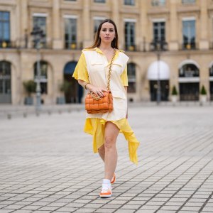 PARIS, FRANCE - MAY 07: Maria Rosaria Rizzo @lacoquetteitalienne wears a pale pastel yellow and beige shirt / flowing dress from Victoria/Tomas, a brown leather Bottega Veneta bag, sneakers from Nike Air Jordan with orange printed houndstooth patterns, on May 07, 2021 in Paris, France. (Photo by Edward Berthelot/Getty Images)