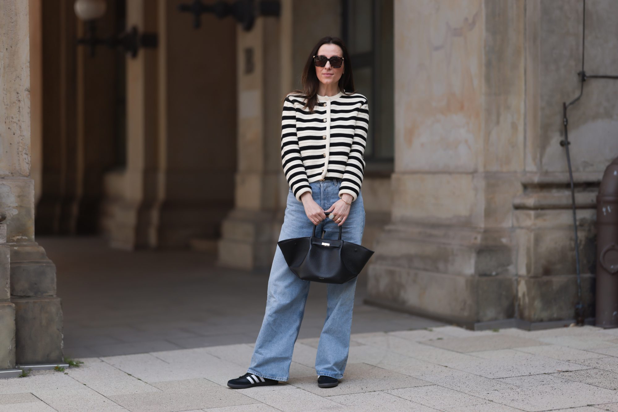 HAMBURG, GERMANY - MAY 09: Elise Seitz seen wearing Bottega Veneta black shades, Celine black belt, Adidas black samba sneaker, Agolde blue jeans, Massimo Dutti striped black and white cardigan and Demellier black bag on May 09, 2023 in Hamburg, Germany. (Photo by Jeremy Moeller/Getty Images)