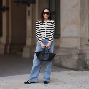 HAMBURG, GERMANY - MAY 09: Elise Seitz seen wearing Bottega Veneta black shades, Celine black belt, Adidas black samba sneaker, Agolde blue jeans, Massimo Dutti striped black and white cardigan and Demellier black bag on May 09, 2023 in Hamburg, Germany. (Photo by Jeremy Moeller/Getty Images)