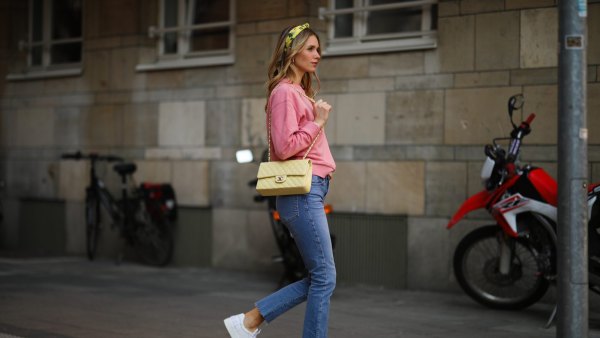 DUSSELDORF, GERMANY - MARCH 24: Scarlett Gartmann wearing pink Vogue sweater, Zara blue jeans, yellow H&M headband, yellow Chanel leather bag and white Chanel sneakers on March 24, 2021 in Dusseldorf, Germany. (Photo by Jeremy Moeller/Getty Images)