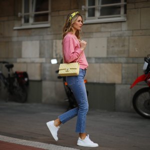 DUSSELDORF, GERMANY - MARCH 24: Scarlett Gartmann wearing pink Vogue sweater, Zara blue jeans, yellow H&M headband, yellow Chanel leather bag and white Chanel sneakers on March 24, 2021 in Dusseldorf, Germany. (Photo by Jeremy Moeller/Getty Images)