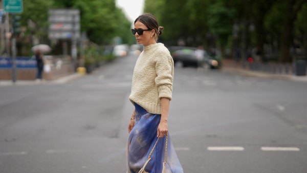 DUSSELDORF, GERMANY - MAY 27: Patricia Wirschke is seen wearing a blue printed silk-organza maxi skirt from Zimmermann, a cream white wool knit sweater with straight fit and round neckline from Jil Sander, brown cat-eye sunglasses with tortoiseshell finish from Celine, a beige small calfskin Chanel 25 hobo handbag with golden hardware and chain and logo details from Chanel, yellow golden Serpenti Viper hoop earrings with snake-like design from Bvlgari, a golden Juste un Clou bracelet from Cartier, a yellow golden Serpenti Viper bracelet with snake-like design from Bvlgari, a yellow golden Love bracelet from Cartier, a silver diamond ring on May 27, 2025 in Dusseldorf, Germany. (Photo by Moritz Scholz/Getty Images)