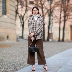 BERLIN, GERMANY - JANUARY 15: Maria Barteczko is seen wearing white turleneck COS, brown checked shirt Zara, brown corduroy pants Zara, black leather strap sandals Zara, black bag Chanel boy, gold round retro glasses Ray Ban during the Berlin Fashion Week Autumn/Winter 2019 on January 15, 2019 in Berlin, Germany. (Photo by Christian Vierig/Getty Images)