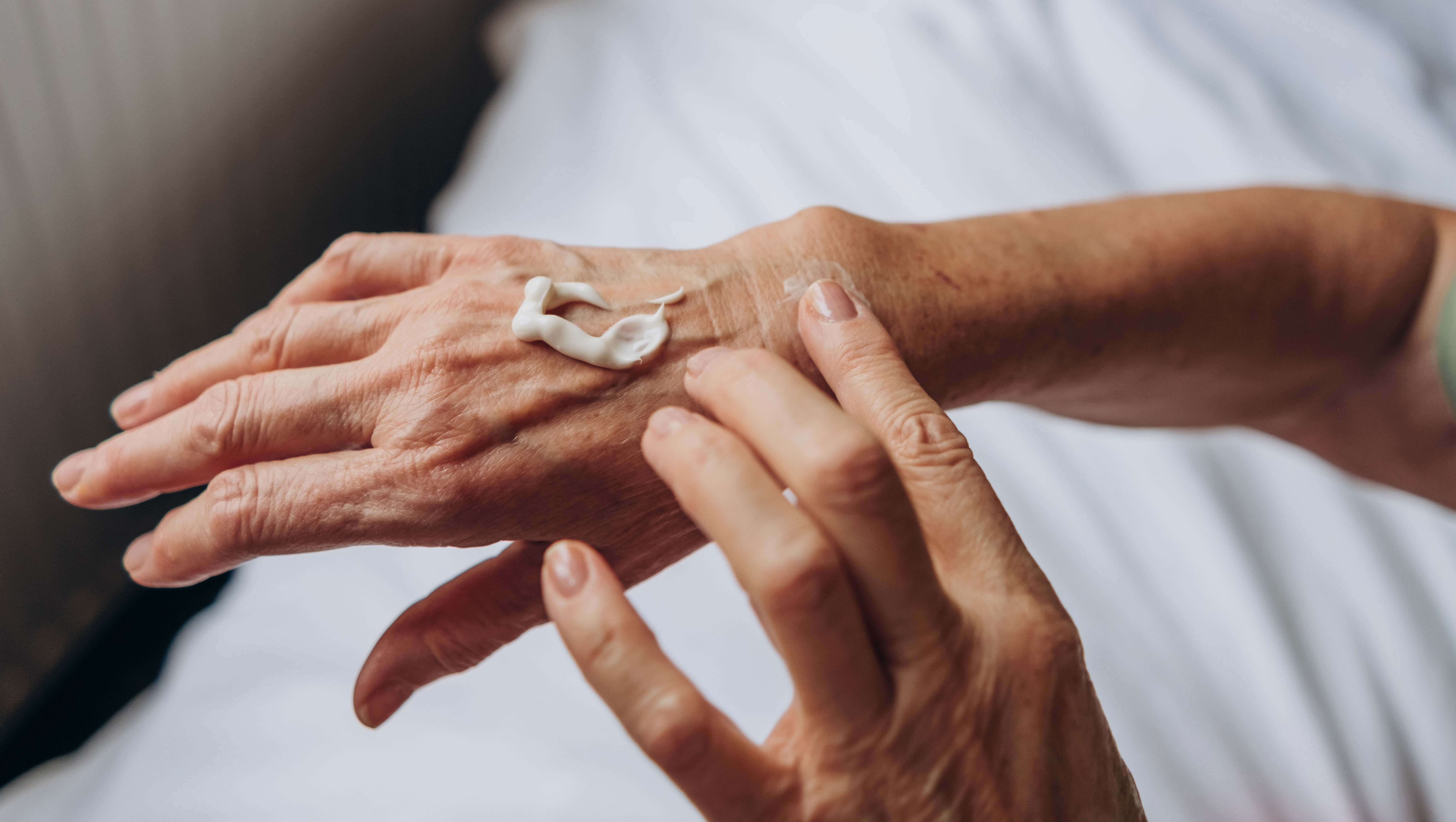 Women senior takes care of herself. senior woman applying cream to her hands - stock photo