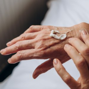 Women senior takes care of herself. senior woman applying cream to her hands - stock photo