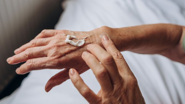 Women senior takes care of herself. senior woman applying cream to her hands - stock photo