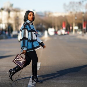 PARIS, FRANCE - JANUARY 09: Carrole Sagba aka "Linaose" wears a blue and white checked wool jacket from Zara, a purple / burgundy leather Hermes Birkin bag, black leggings/pants from Acne Studios, black pointy high heeled knee-high leather boots with printed crocodile patterns from Dear Frances, on January 09, 2021 in Paris, France. (Photo by Edward Berthelot/Getty Images)