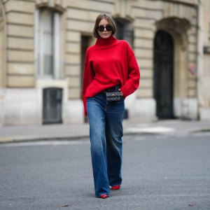 PARIS, FRANCE - NOVEMBER 10: Diane Batoukina wears black sunglasses, a red wool ribbed turtleneck pullover, a black shiny leather belt bag from Chanel, blue faded denim wide legs pants, red shiny varnished leather pointed pumps heels shoes, during a street style fashion photo session, on November 10, 2022 in Paris, France. (Photo by Edward Berthelot/Getty Images)