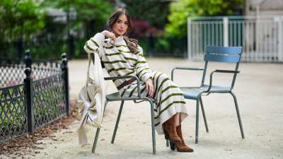 PARIS, FRANCE - APRIL 23: Heart Evangelista wears earrings, a black and white turtleneck striped long dress, a leather belt, high heels pointed suede boots from YSL Saint-Laurent, sits on a chair, during a street style fashion photo session, on April 23, 2024 in Paris, France. (Photo by Edward Berthelot/Getty Images)