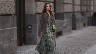 BERLIN, GERMANY - FEBRUARY 16: Anna Hiltrop seen wearing Boss green / beige / black print pattern pleated long dress, Boss brown suede leather jacket, Michael Kors green leather quilted crossbody bag and Gucci black leather laced boots, on February 16, 2024 in Berlin, Germany. (Photo by Jeremy Moeller/Getty Images)