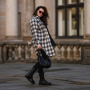 HAMBURG, GERMANY - FEBRUARY 07: Dayami Candebat is seen wearing Kaffe curve long flanell, Ducie black boots, big Bottega Veneta Jodie black leather bag, Prada black shades, cap and beige jacket on February 07, 2022 in Hamburg, Germany. (Photo by Jeremy Moeller/Getty Images)
