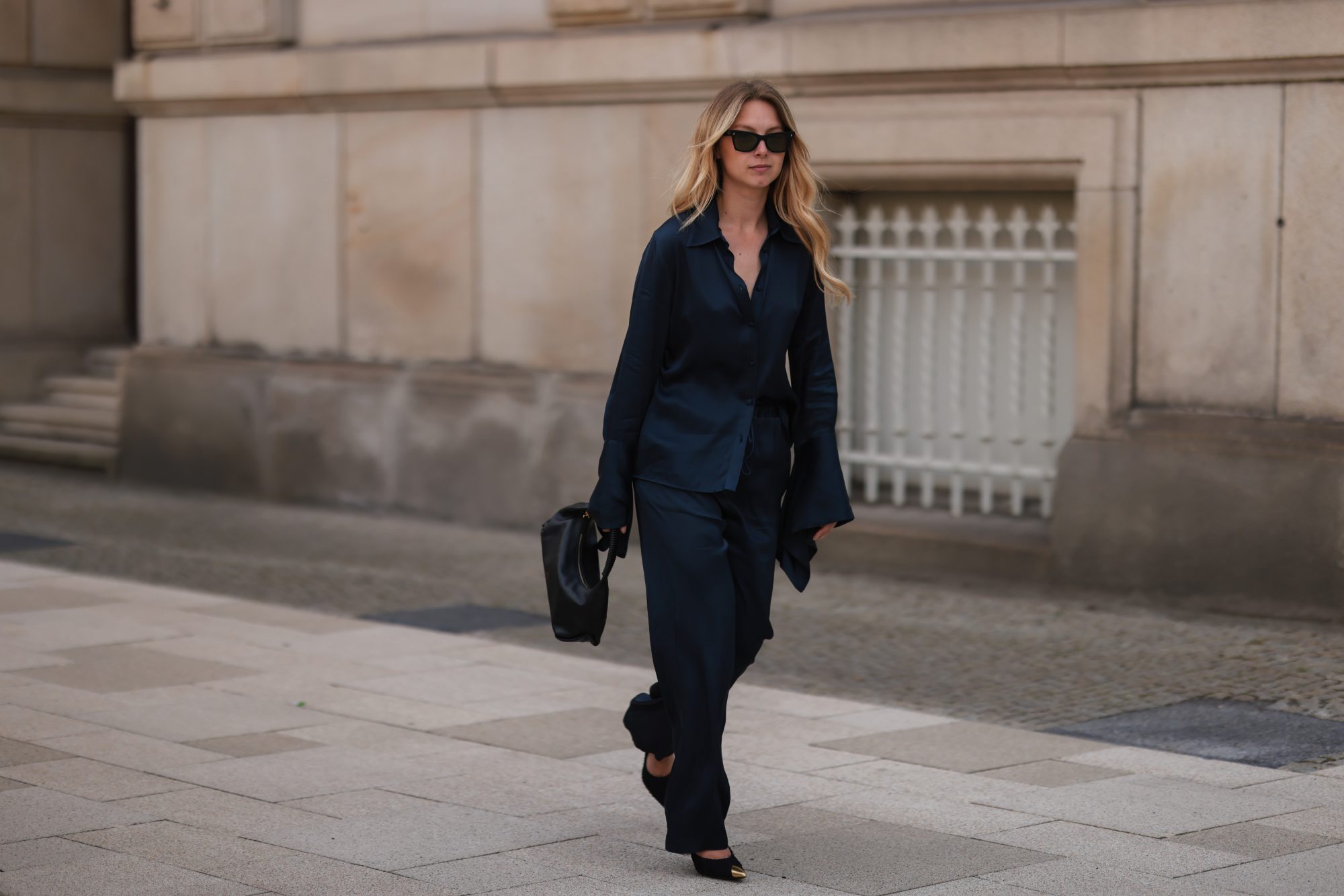 HAMBURG, GERMANY - JUNE 09: Liesa Späht seen wearing black sunglasses from Celine, a dark blue silk blouse from SoSue, a matching dark blue silk wide leg pants from SoSue, black heels from Saint Laurent and a black leather Khaite bag on June 09, 2022 in Hamburg, Germany. (Photo by Jeremy Moeller/Getty Images)