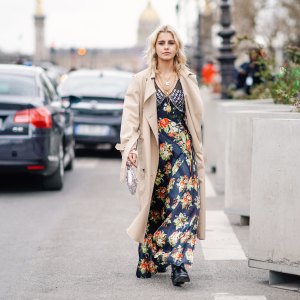 PARIS, FRANCE - FEBRUARY 28: Caroline Daur wears a trench coat, a floral print dress, a silver bag, a necklace, outside Paco Rabanne, during Paris Fashion Week Womenswear Fall/Winter 2019/2020, on February 28, 2019 in Paris, France. (Photo by Edward Berthelot/Getty Images)