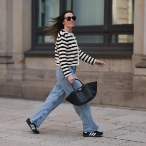 Elise Seitz seen wearing Bottega Veneta black shades, Celine black belt, Adidas black samba sneaker, Agolde blue jeans, Massimo Dutti striped black and white cardigan and Demellier black bag on May 09, 2023 in Hamburg, Germany.