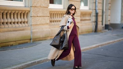 DUESSELDORF, GERMANY - AUGUST 19: Patricia Wirschke is seen wearing a classic beige long Herno trench coat, with a notched collar, storm flap, and belted cuffs; a burgundy Incentive co ord set with a cable-knit sweater, featuring a ribbed hem, cuffs, and neckline and wide-leg knit pants with a relaxed fit; a pair of Le Loafer soft suede Saint Laurent moccasins in dark brown with golden logo detail on the side; a dark brown Hop bag from Bottega Veneta with the famous Intrecciato leather construction, woven; Tom Ford Ilias squared frame black sunglasses with orange toned lens; Bvlgari Serpenti Viper golden earrings; her brown hair is styled in a straight, shoulder-length look with a middle part; she holds a rolled up magazine in her hand on August 19, 2025 in Duesseldorf, Germany. (Photo by Moritz Scholz/Getty Images)