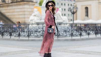 Alexandra Lapp wearing Boho Style, a red and cream floral print maxi dress from Philosophy di Lorenzo Serafini in sheer silk chiffon and bold black trims with a ribbon tie, Toubootfrou ankle boots with rete, organze and suede in black from Christian Louboutin, Celine Audrey sunglasses in black, Maison Maison Michel hat Virginie fedora, MCM Patricia Shoulder Bag in a vintage shape during the Mercedes-Benz Fashion Week Berlin Spring/Summer 2018 on July 7, 2017 in Berlin, Germany.