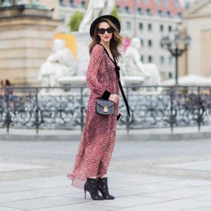 Alexandra Lapp wearing Boho Style, a red and cream floral print maxi dress from Philosophy di Lorenzo Serafini in sheer silk chiffon and bold black trims with a ribbon tie, Toubootfrou ankle boots with rete, organze and suede in black from Christian Louboutin, Celine Audrey sunglasses in black, Maison Maison Michel hat Virginie fedora, MCM Patricia Shoulder Bag in a vintage shape during the Mercedes-Benz Fashion Week Berlin Spring/Summer 2018 on July 7, 2017 in Berlin, Germany.
