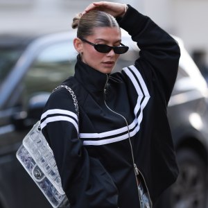 BERLIN, GERMANY - APRIL 08: Sophia Geiss seen wearing Yves Saint Laurent bold, rectangular black sunglasses, minimal hoop earrings, Black Palms sporty black zip-up with high collar and oversized fit tracking jacket featuring bold white horizontal stripes across the chest and sleeves, Acne Studios wide-leg dirty jeans that are intentionally distressed and splattered with white paint, Chanel silver metallic flap bag / standout silver quilted handbag with a chunky chain strap, on April 08, 2025 in Berlin, Germany. (Photo by Jeremy Moeller/Getty Images)