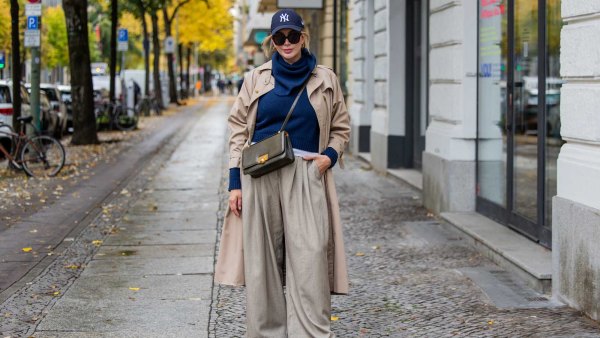 A woman walking in the cirt wearing Fall Trousers and a long jacket.