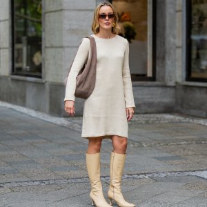 BERLIN, GERMANY - AUGUST 03: Tina Haase wears by Malene Birger butter yellow dress with long sleeves, beige Tony Bianco high knee boots, Liebeskind brown Suede shoulder bag, Le Specs sunglasses on August 03, 2025 in Berlin, Germany. (Photo by Christian Vierig/Getty Images)