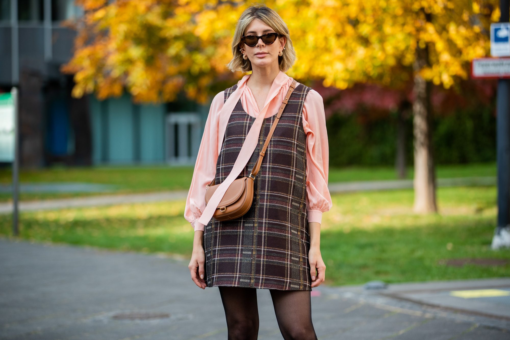 FRANKFURT AM MAIN, GERMANY - OCTOBER 26: Victoria Scheu is seen wearing mini checkered dress and salmon colored bow-tie blouse Nobi Talai, sheer tights, cat-eye sunglasses Mango, brown bag Carolina Herrera on October 26, 2020 in Frankfurt am Main, Germany. (Photo by Christian Vierig/Getty Images)