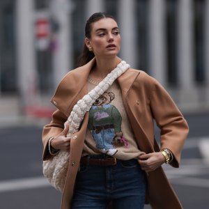 BERLIN, GERMANY - NOVEMBER 09: Celine Bethmann seen wearing gold earrings, Ralph Lauren beige wool teddy knit sweater, Liu Jo brown wool short coat, COS cream white crossbody bag, Zara blue denim jeans / pants, on November 09, 2023 in Berlin, Germany. (Photo by Jeremy Moeller/Getty Images)