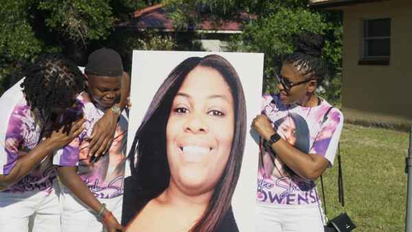 A group of people hold up a poster in The Perfect Neighbor