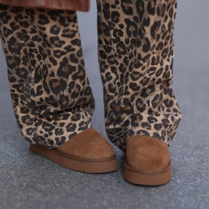 VIENNA, AUSTRIA - NOVEMBER 05: Karin Teigl is seen wearing a calf-length brown leather coat from Prada, wide jeans in leopard print from Bershka, and brown suede platform slippers from Copenhagen Studios on November 05, 2024 in Vienna, Austria. (Photo by Jeremy Moeller/Getty Images)