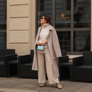 Elise Soho wearing Birkenstock beige sandals, Joseph beige two piece, Nanushka beige coat, Loewe mini blue baby bag on August 30, 2021 in Hamburg, Germany.