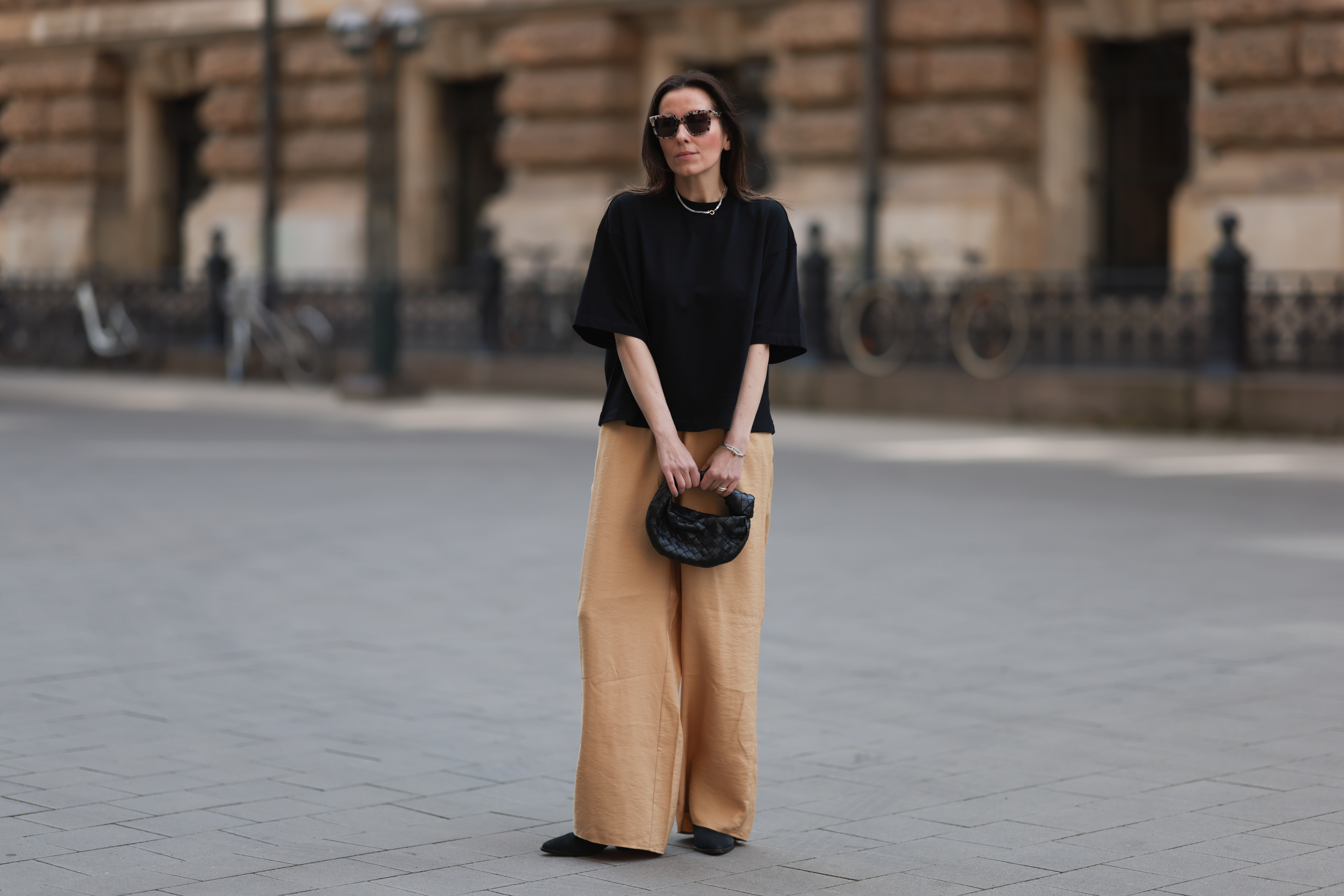 HAMBURG, GERMANY - MAY 09: Elise Seitz seen wearing a Bottega Veneta Jodie black leather bag, Isabel Marant black boots, Soho Studios black shirt and beige and brown pants and Ace and Tate black shades on May 09, 2023 in Hamburg, Germany. (Photo by Jeremy Moeller/Getty Images)