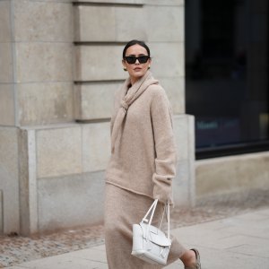 Laura Noltemeyer is seen wearing an oversized beige alpaca wool sweater with tie-back detailing by Aylin König; a long alpaca wool knit skirt in a straight cut by Aylin König; an alpaca knit scarf draped and knotted around the neck by Aylin König; a white intrecciato leather handbag called „Arco Bag“ by Bottega Veneta; slim black cat-eye sunglasses by Yves Saint Laurent; gold statement earrings with a green stone detail by Mango; her brown and straight hair is tied in a low ponytail on October 16, 2025 in Hamburg, Germany.