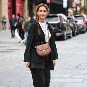 Katie Holmes spotted with her hair in a long braid and wearing a DeMellier bag on October 29, 2025 in New York City.