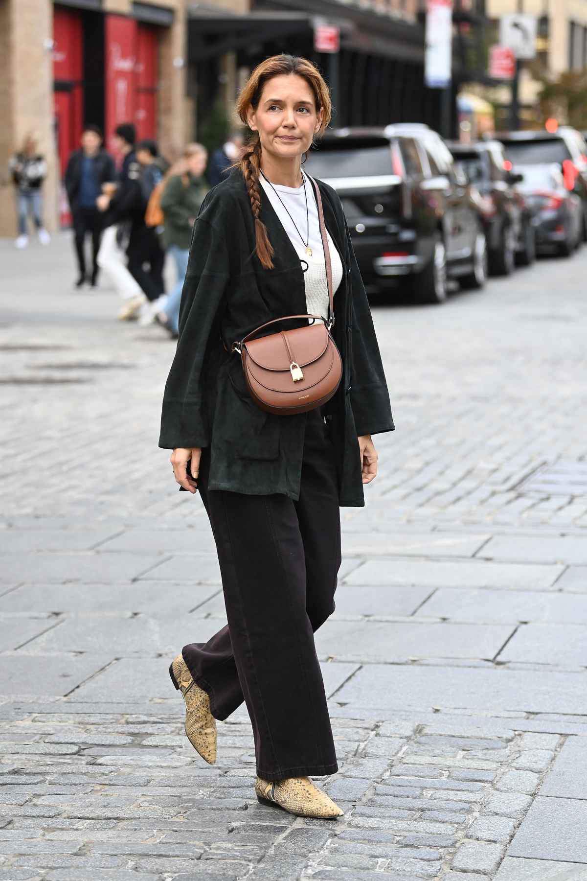 Katie Holmes spotted with her hair in a long braid and wearing a DeMellier bag on October 29, 2025 in New York City.