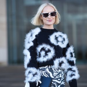 COPENHAGEN, DENMARK - JANUARY 31: Thora Valdimars wears a black and white full look, sunglasses, a floral print fluffy pullover , striped zebra print pants,, a Chanel bi-color clutch, outside OperaSport, during the Copenhagen Fashion Week AW24 on January 31, 2024 in Copenhagen, Denmark. (Photo by Edward Berthelot/Getty Images)