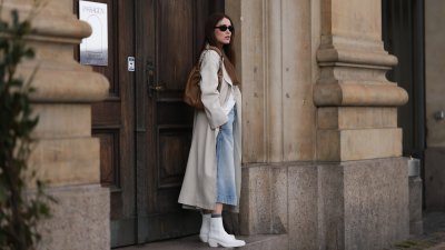 COPENHAGEN, DENMARK - AUGUST 10: Annabel Rosendahl seen wearing black sunglasses, white shirt, beige long coat, light blue denim skirt, brown leather bag and Copenhagen StudiosCPH236 Nappa White leather boots, on August 10, 2023 in Copenhagen, Denmark. (Photo by Jeremy Moeller/Getty Images for The Wants Social / Copenhagen Studios)