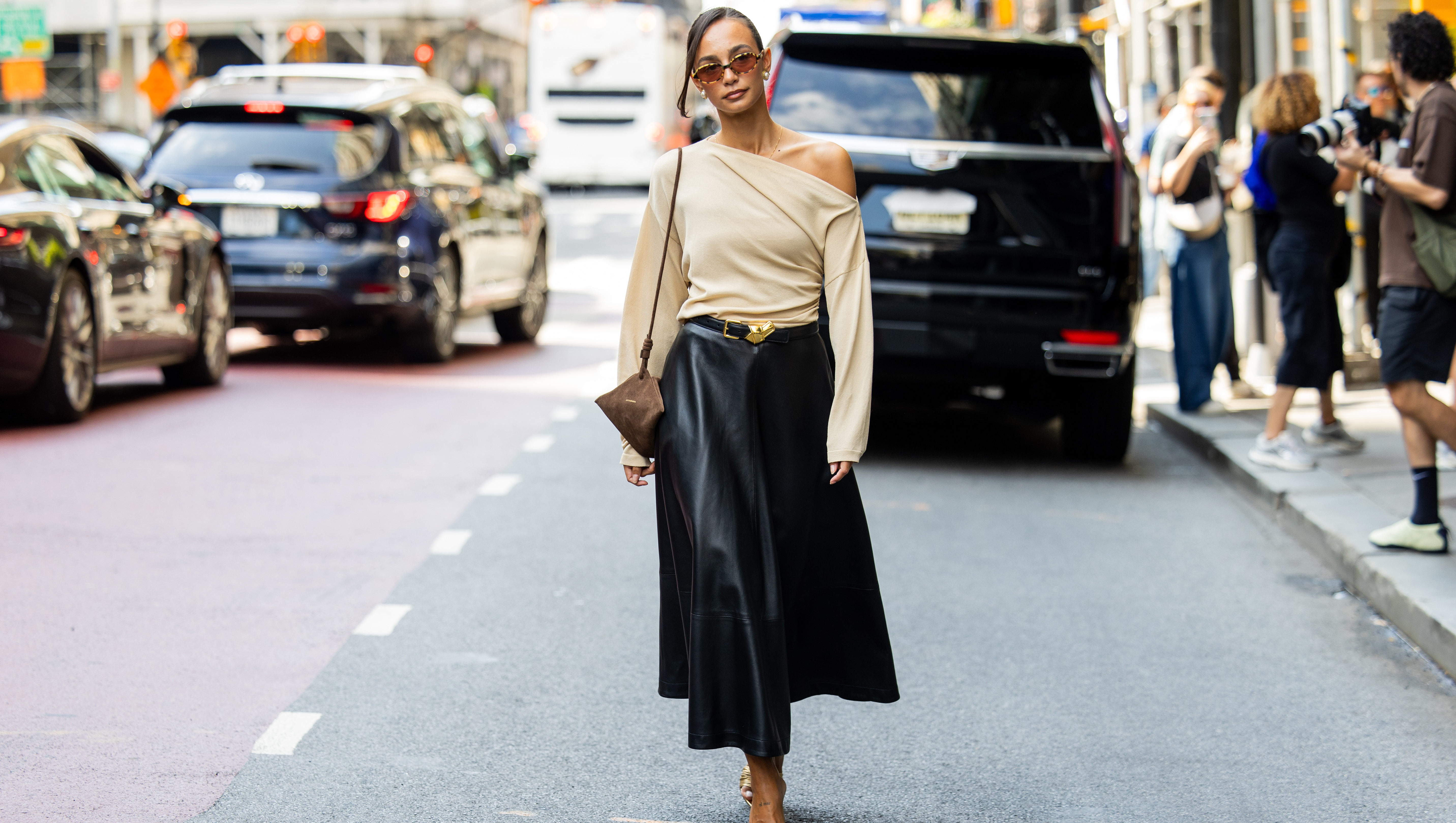 NEW YORK, NEW YORK - SEPTEMBER 13: Blanca Arimany wears beige asymmetric top, black leather skirt, brown suede bag, heels, sunglass outside Altuzarra during New York Fashion Week on September 13, 2025 in New York City. (Photo by Christian Vierig/Getty Images)